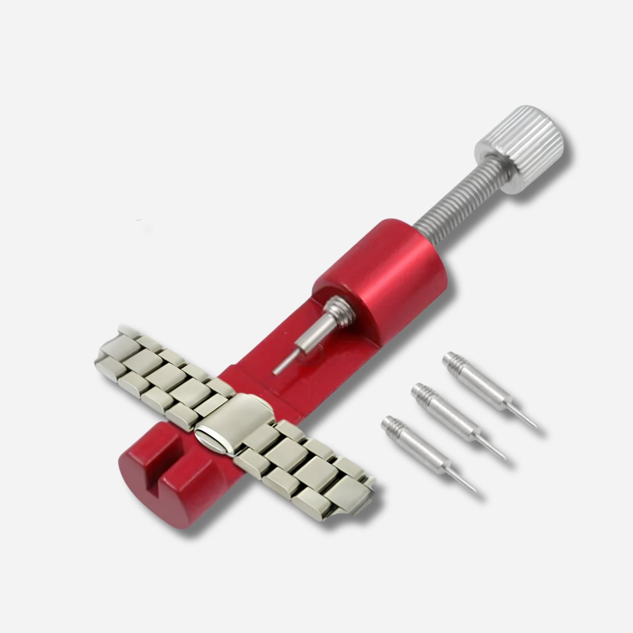 Metal watch band link pin remover tool in red, inserted into a stainless steel bracelet link, with 3 extra replacement pins displayed beside it on a white background
