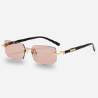 Sunglasses with gold frame and pink lenses on a light gray background