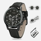 Black watch with leather strap, cufflinks, and tie clip on a white background