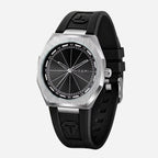 A Tomi brand watch with a brushed silver-tone octagonal case, a black dial with silver hands and markers, and a black rubber strap with a debossed logo.