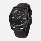 Black watch with brown leather strap on a light gray background