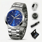 Silver watch with blue face and accessories on a white background