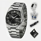 Silver watch with black face, ring, crown, and pen on a white background