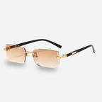 Sunglasses with gold gradient lenses and black frames on a light gray background