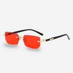Sunglasses with red lenses and black and gold frames on a white background