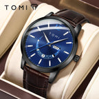Tomi watch with blue dial and brown leather strap on a beige cushion