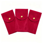 Three red fabric pouches with gold buttons on a white background