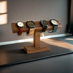 Wooden watch stand with four watches on a reflective surface