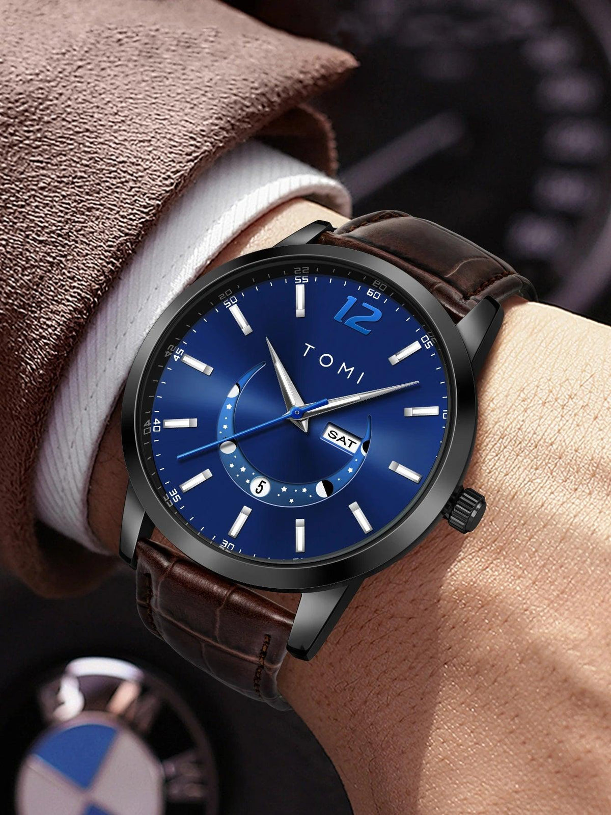 Wristwatch with blue dial and brown leather strap on a wrist, brand 'TOMI' visible.