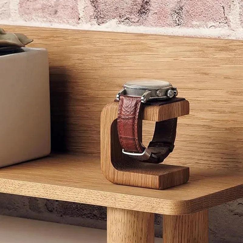 Wooden watch stand with a watch on a wooden surface