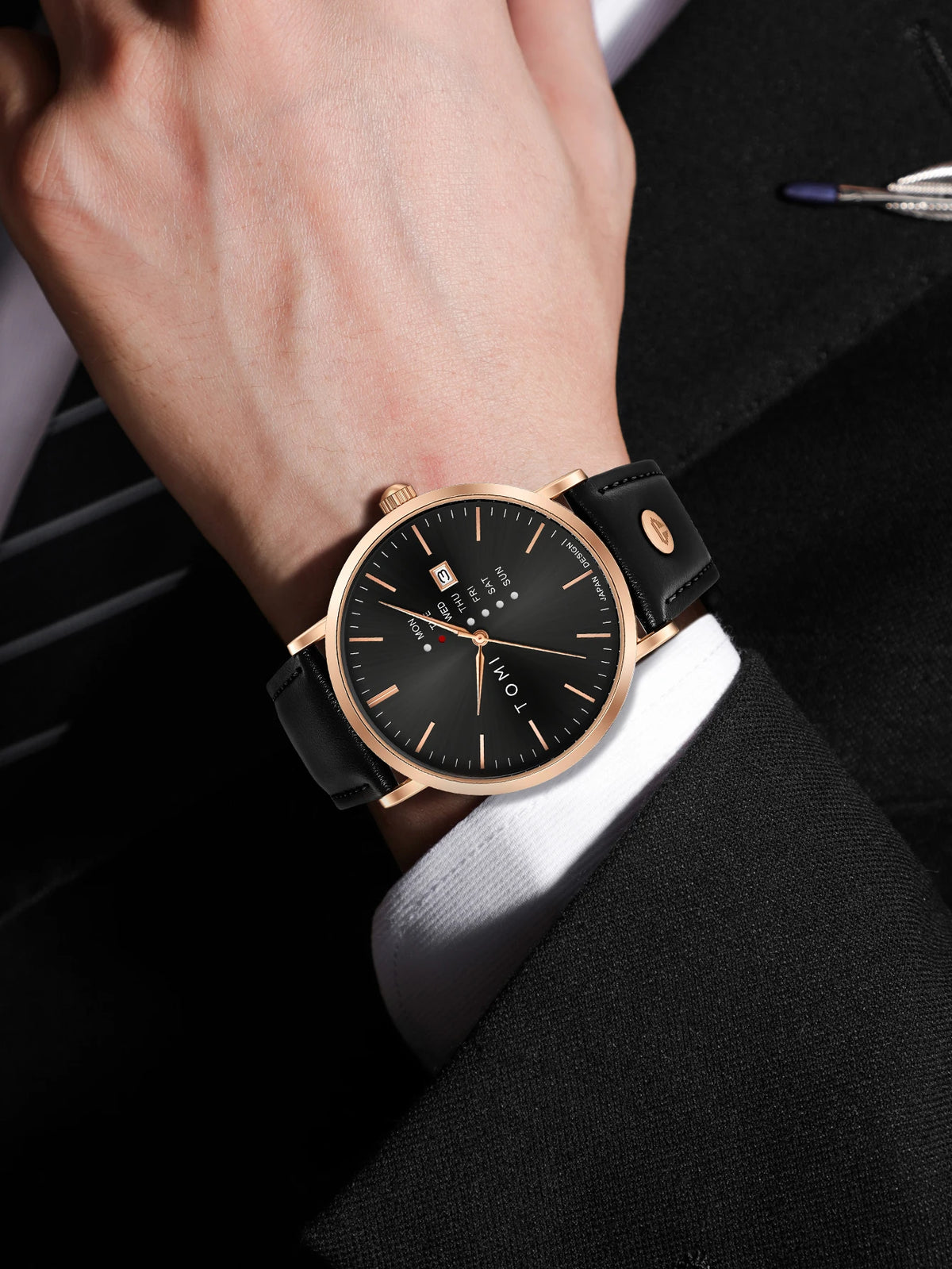 Black watch with rose gold case on a wrist, close-up shot.