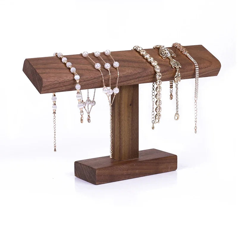 Wooden jewelry stand with various necklaces and bracelets on a white background