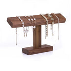 Wooden jewelry stand with various necklaces and bracelets on a white background