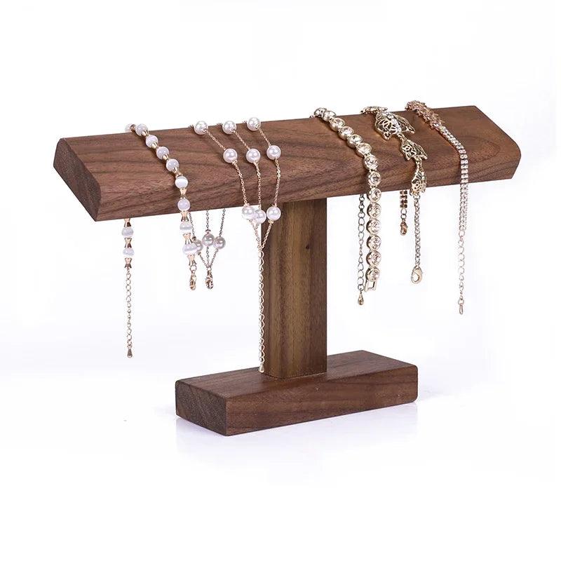 Wooden jewelry stand with various necklaces and bracelets on a white background
