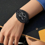 A black rugged sports watch with a digital display and analog face, worn on a person's wrist against a dark textured tabletop.