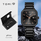 Black watch with rose gold accents and gift box on a blue background, featuring the TOMI brand.