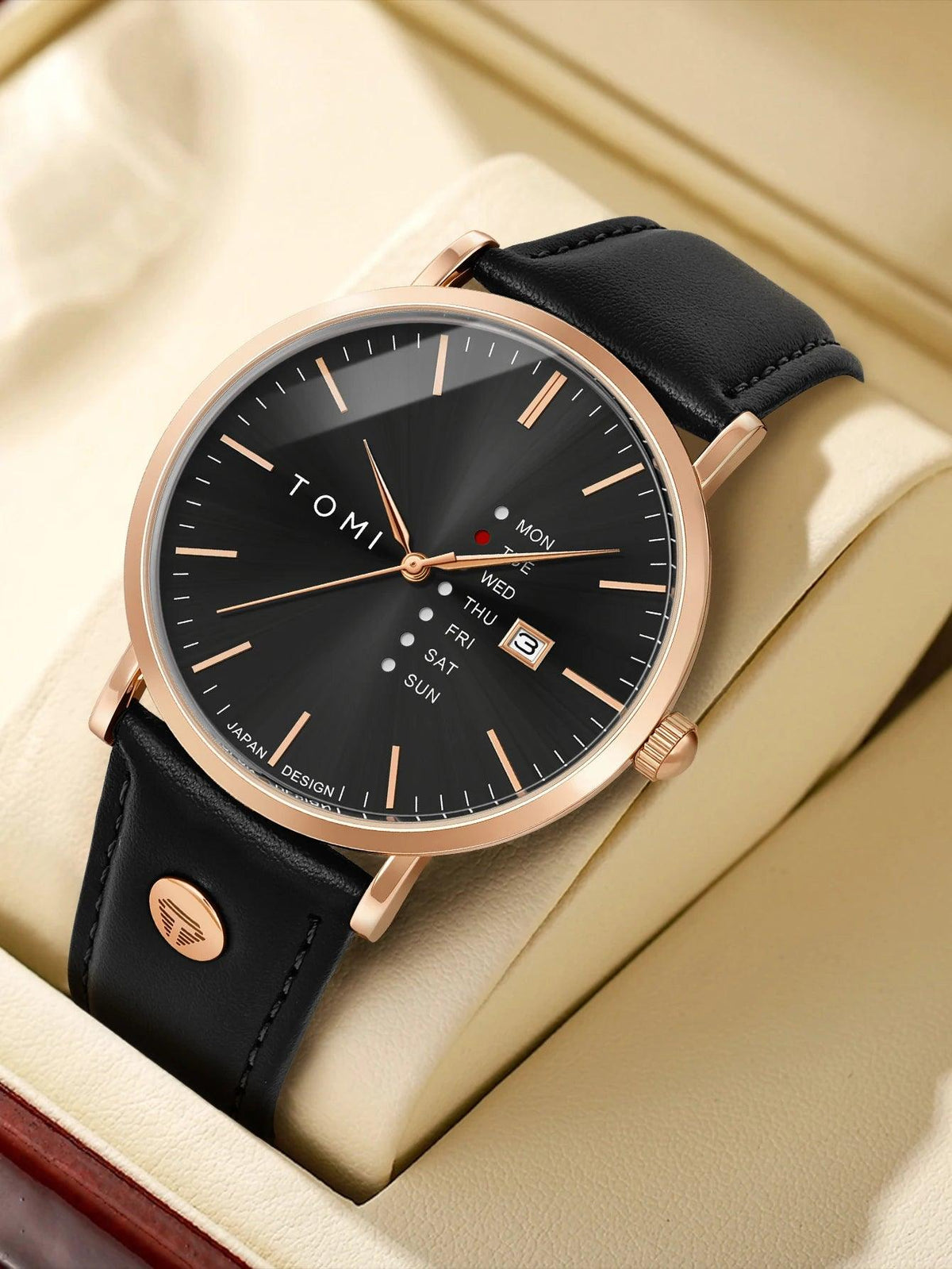 Tomi watch with black leather strap and rose gold case on beige fabric background