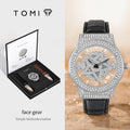Luxury watch with intricate design and black leather strap, displayed with TOMI packaging.