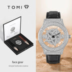 Luxury watch with intricate design and black leather strap, displayed with TOMI packaging.