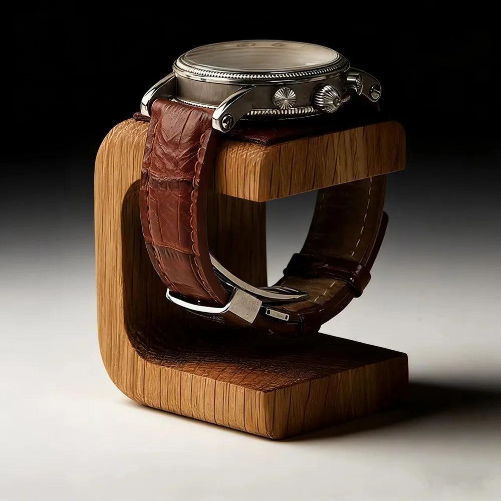Watch with brown leather strap on a wooden stand against a dark background
