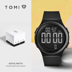 Black digital watch with a box on a light gray background, featuring the brand 'TOMI'.