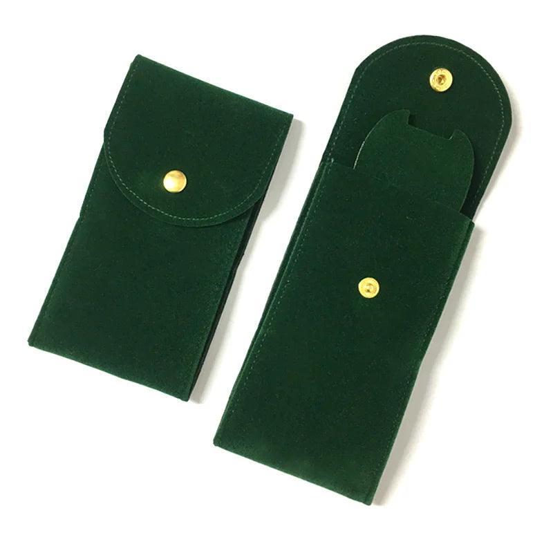 Two green velvet pouches with gold buttons on a white background