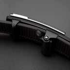 Close-up of a black knife blade with a metallic handle on a dark background