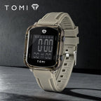 Digital watch with beige strap on a dark background, featuring the TOMI brand.