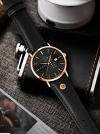 Black watch with rose gold accents on a textured surface
