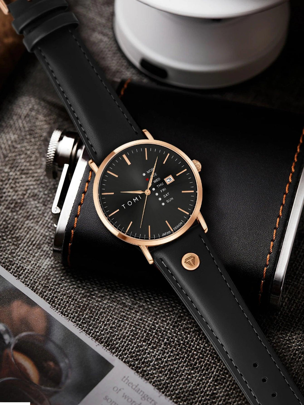 Black watch with rose gold accents on a textured surface