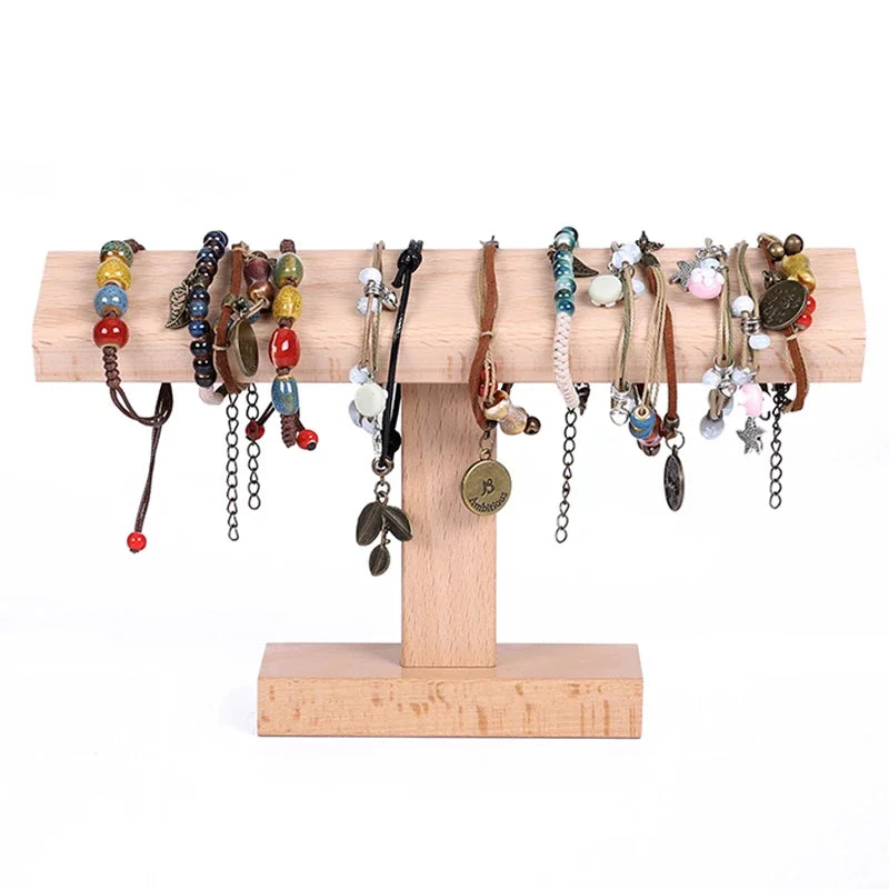 Wooden bracelet holder with various bracelets on a white background
