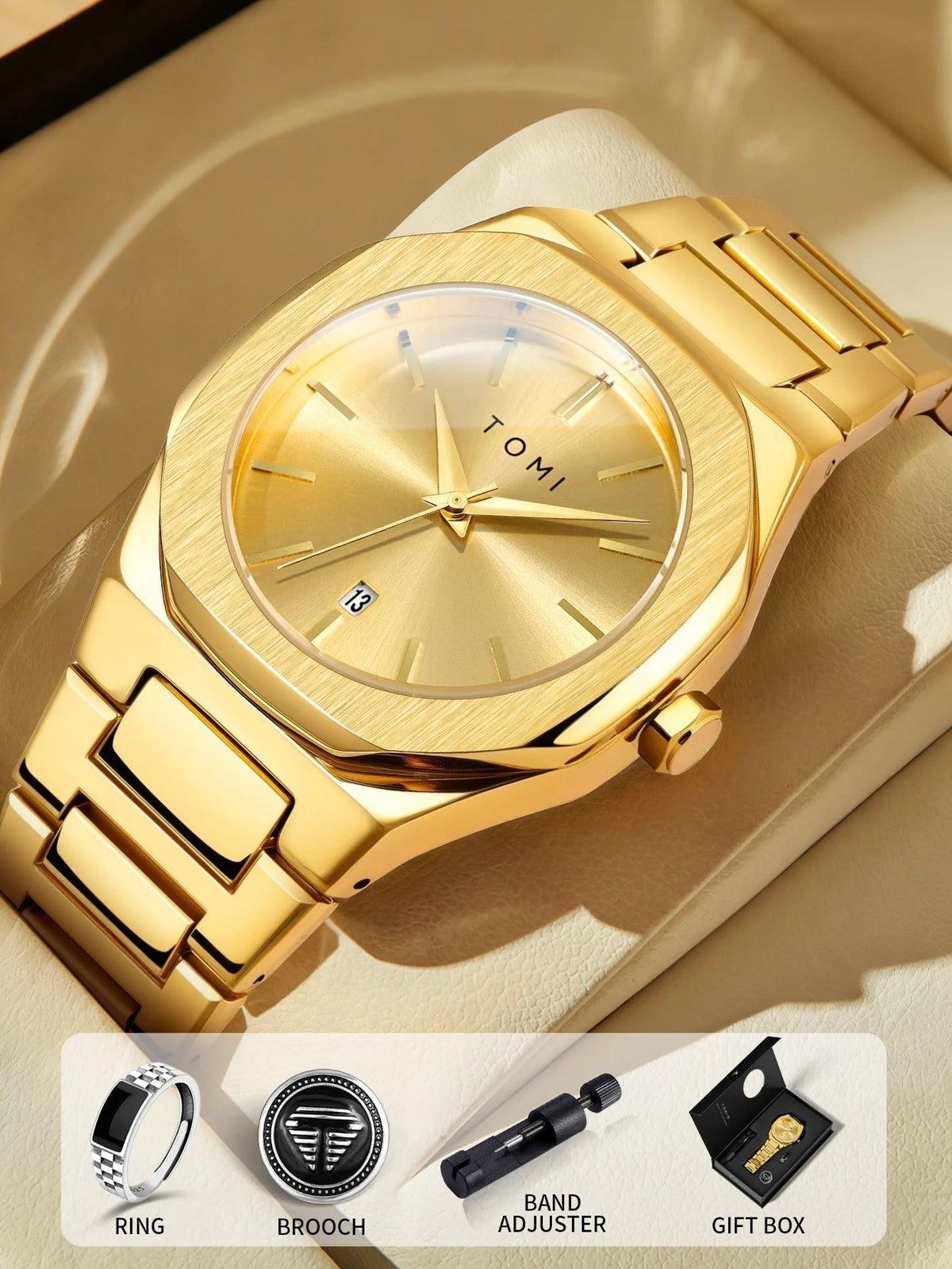 Gold-tone stainless steel men's watch with a matching metal bracelet, gold dial, and date window, displayed on a beige surface with included accessories shown in a bottom banner: ring, brooch, band adjuster, and gift box. The watch face shows the brand TOMI.