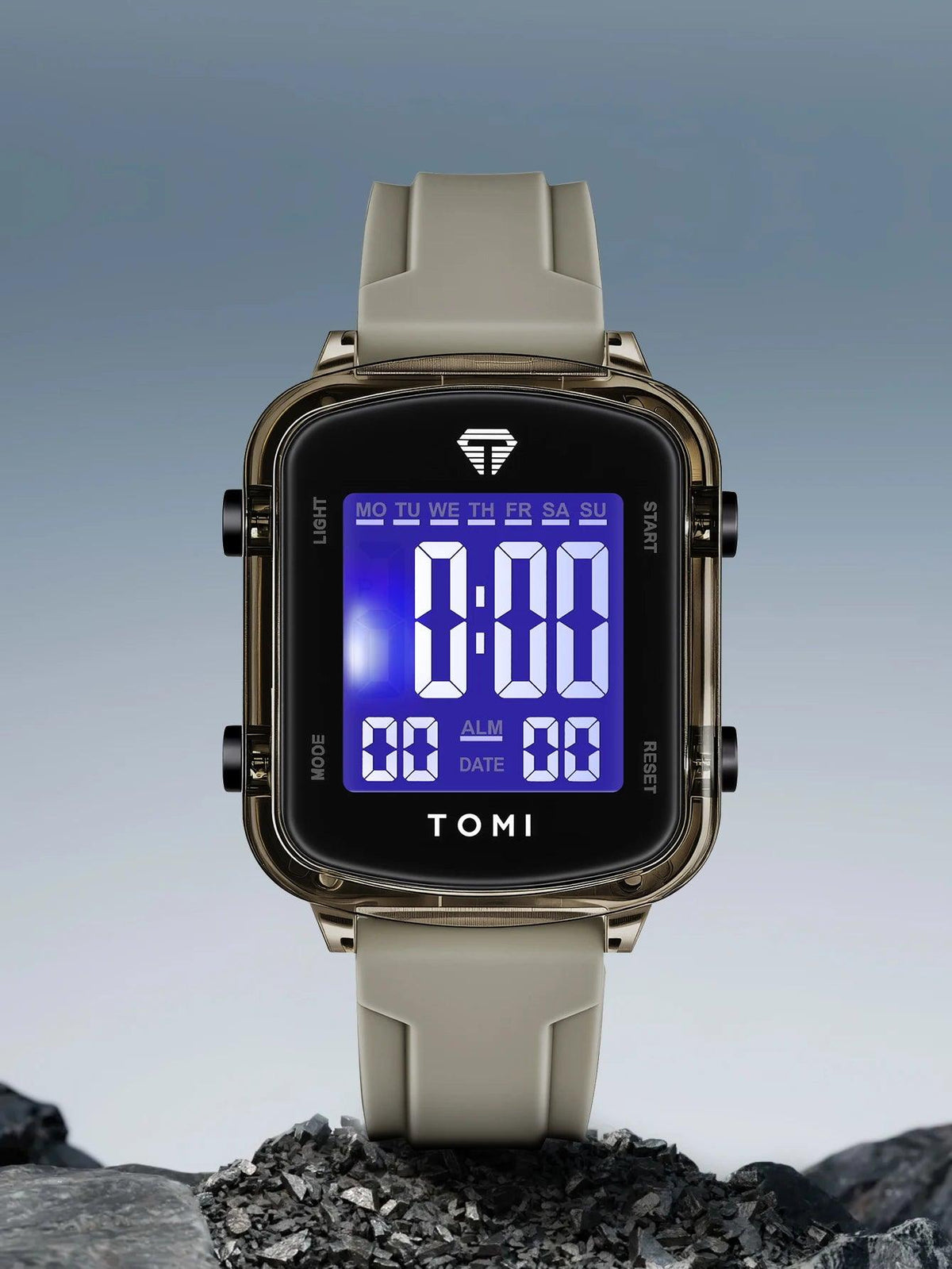 Digital watch with a gray strap on a rocky surface