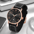 Black watch with rose gold accents on a reflective surface