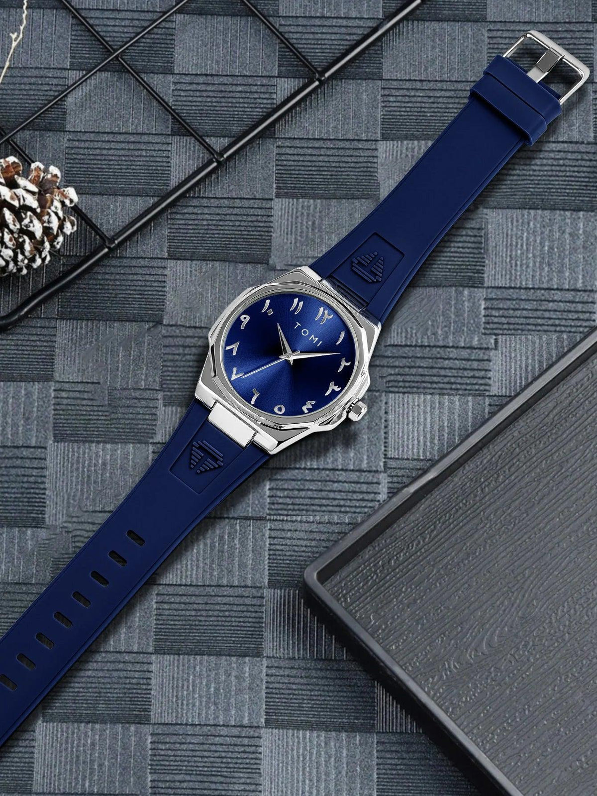 TOMI T051 blue dial watch flat lay on dark background