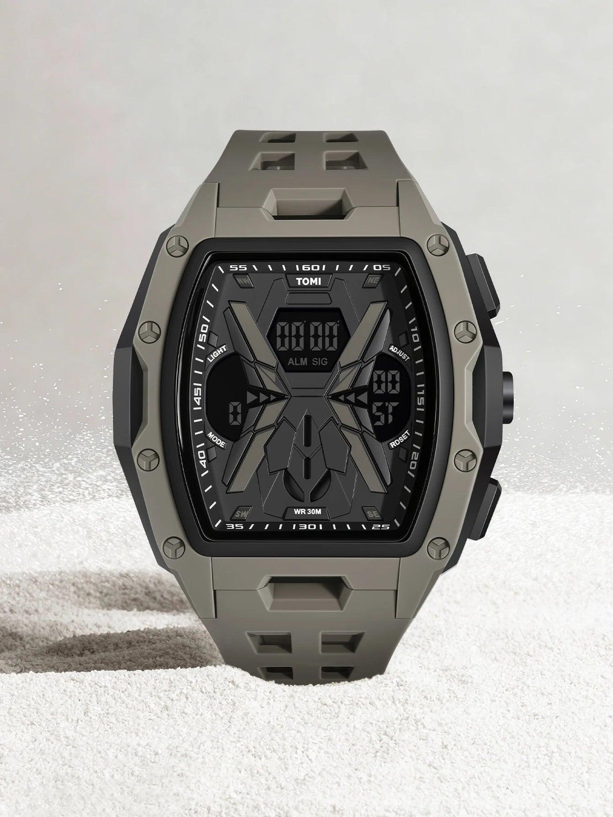 A rugged tactical watch with an olive green and black case and strap, featuring a digital display on a light gray textured background.