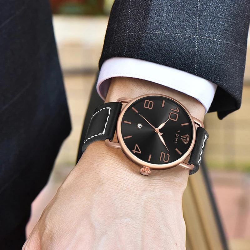 Rose gold watch with black strap on a person's wrist, wearing a suit.