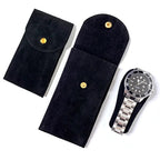 Black velvet watch pouches with gold buttons and a silver watch on a white background