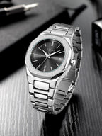 Silver watch with black face on a reflective surface
