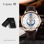 TOMI watch with brown leather strap and white face on a dark background