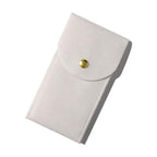 White fabric pouch with a gold button on a white background