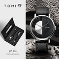TOMI watch with black leather strap and gift box on a textured surface