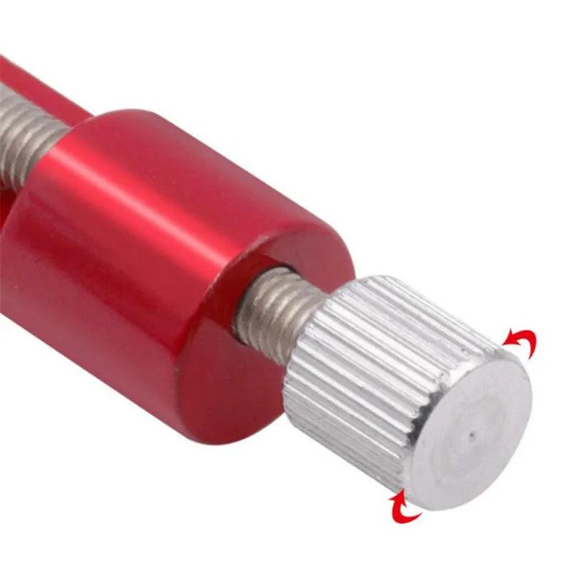 Red metal watch strap link pin adjustment tool, 6.5cm length, showing the screw mechanism and pin tip detail on a white background