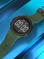 Digital watch with a green strap on a blue reflective surface