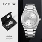 TOMI stainless steel watch shown in a split layout: a large front view on a dark background and a smaller open gift box view on the left. The watch has a silver brushed dial, silver bezel, and matching metal bracelet.