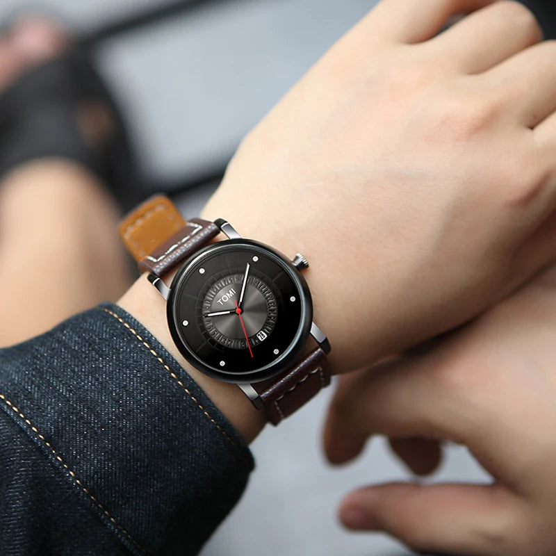 Person wearing a black wristwatch with a brown leather strap.