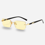 Gold-rimmed sunglasses with black arms on a light gray background
