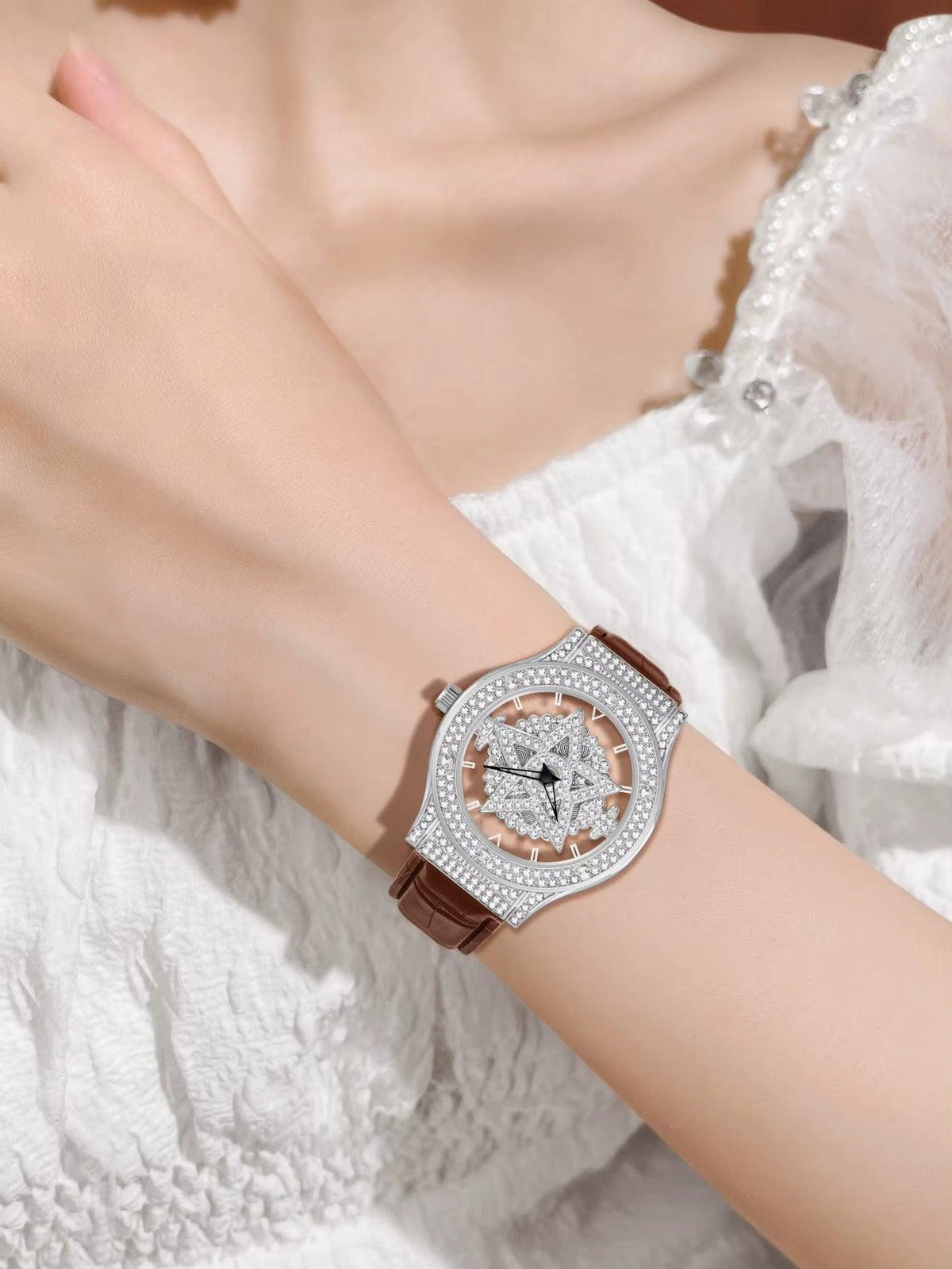 Luxury watch with diamond accents on a wrist against a white lace background