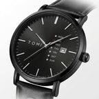 Black watch with black leather strap on a white background, angled view