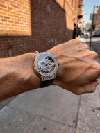 Man wearing TOMI T029 Opulence Radiance watch with silver diamond-set case and black leather strap, close-up street view